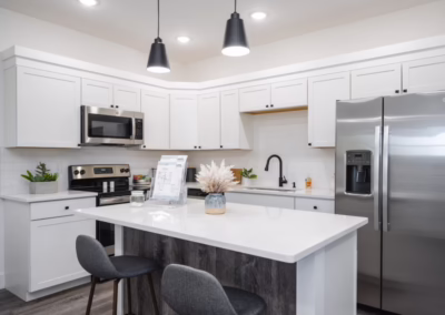 A clean white kitchen with stainless steel appliances