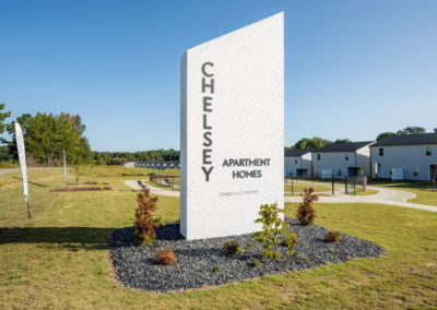A large sign reading "Chelsey Apartment Homes" at the entrance of Sage at Chelsey