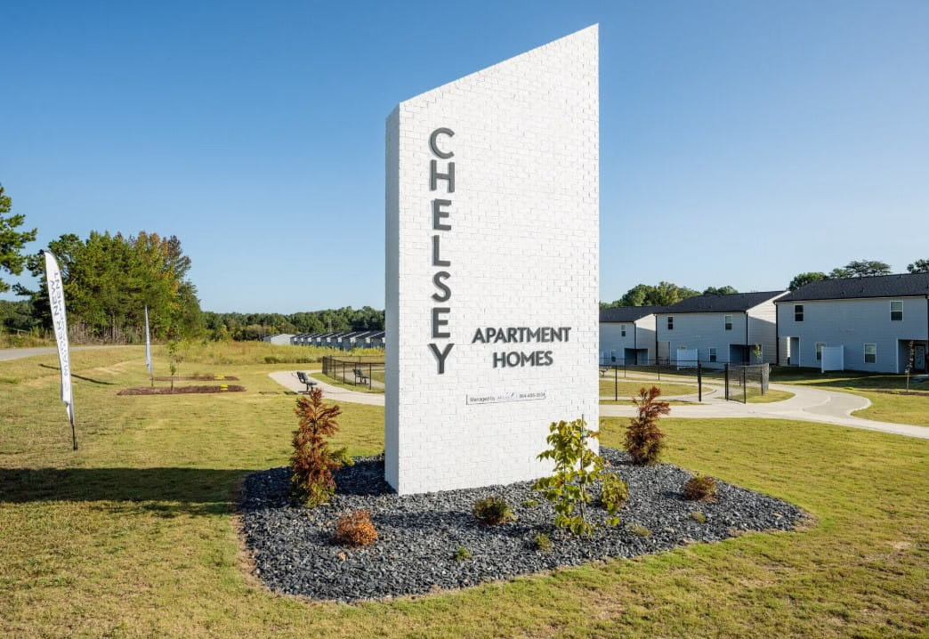A large sign reading "Chelsey Apartment Homes" at the entrance of Sage at Chelsey