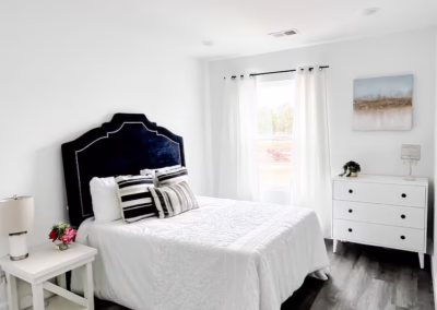 A clean white bedroom with hardwood floors