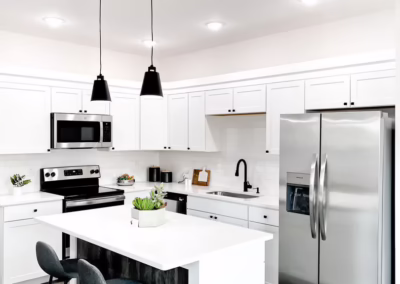 A clean white kitchen with stainless steel appliances