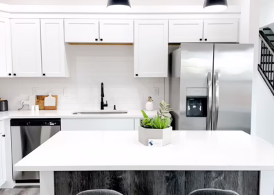 A clean white kitchen with stainless steel appliances